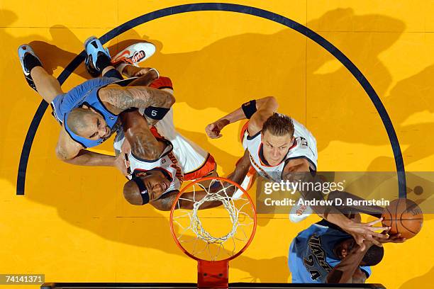 Andris Biedrins of the Golden State Warriors goes up to block a shot attempt with teammate Al Harrington during the game against Paul Millsap and...