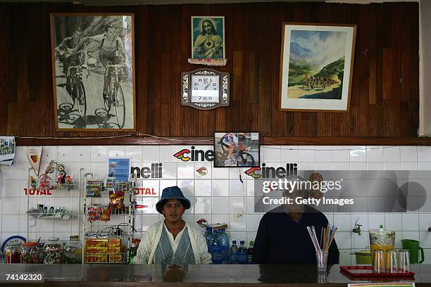 Two cafeteria workers pose in front of a photograph of Faustino Coppi and a painting of the Tour de France at the Alto Irpavi Velodrome, May 13, 2007...