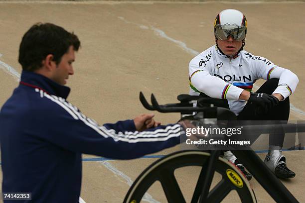 Chris Hoy of Great Britain watches as sports scientist,Scott Gardner makes final adjustments to his bike before his failed attempt to break the World...