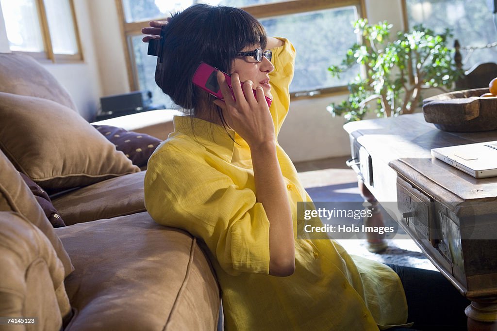 Woman chatting on cell phone in living room