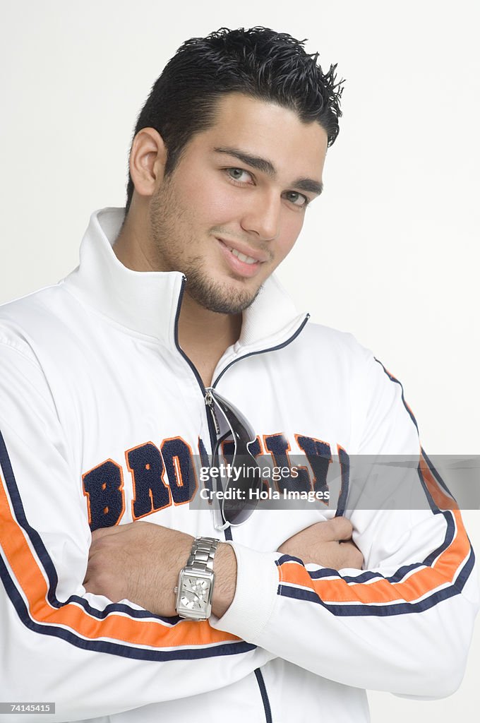 Young man looking at camera, arms crossed