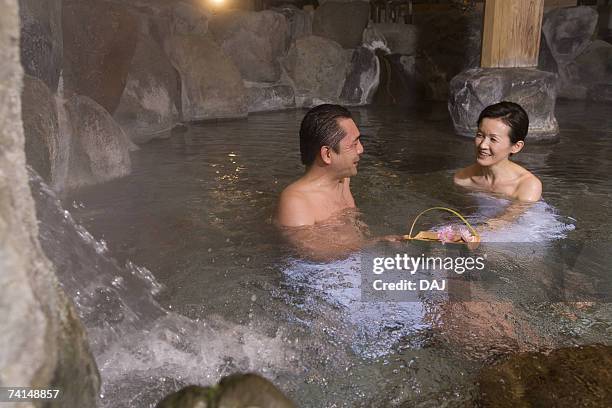 mature adult couple soaking in a hot spring together, side view, head and shoulder - hot spring 個照片及圖片檔