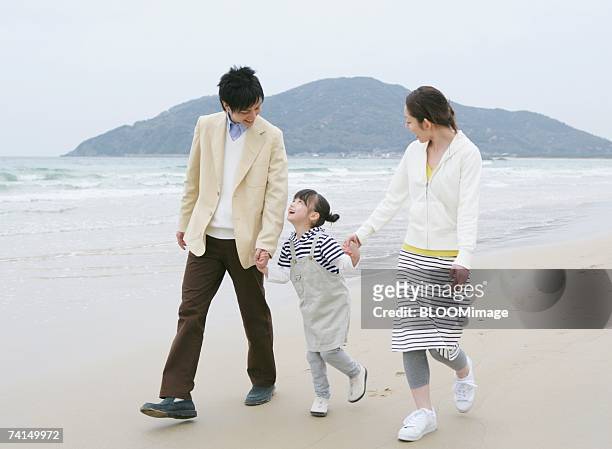 japanese couple and girl walking with holding hands on beach - japanese family ストックフォトと画像