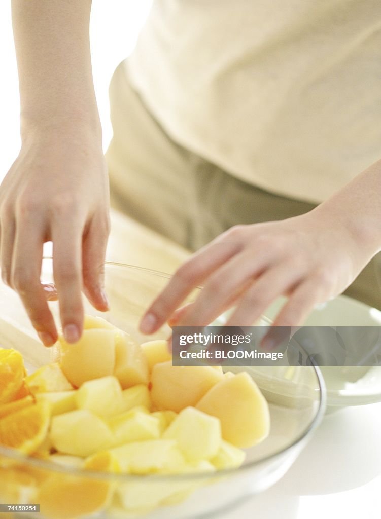 Japanese woman serving cut fruits in bowl