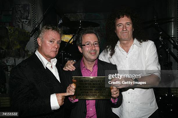 Queen's Roger Taylor and Brian May and writer Ben Elton pose backstage with a plaque to announce We Will Rock You as the longest running musical at...