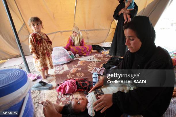 Iraqi refugees from the violence-ridden Diyala province, northeast of Baghdad, sit in their tent, provided by the Iraqi Red Crescent Society in the...