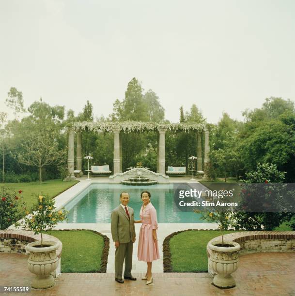 Indian-born actress Merle Oberon with her husband, Italian industrialist Bruno Pagliai, in the garden of their home in Acapulco, 1958. The sculptures...