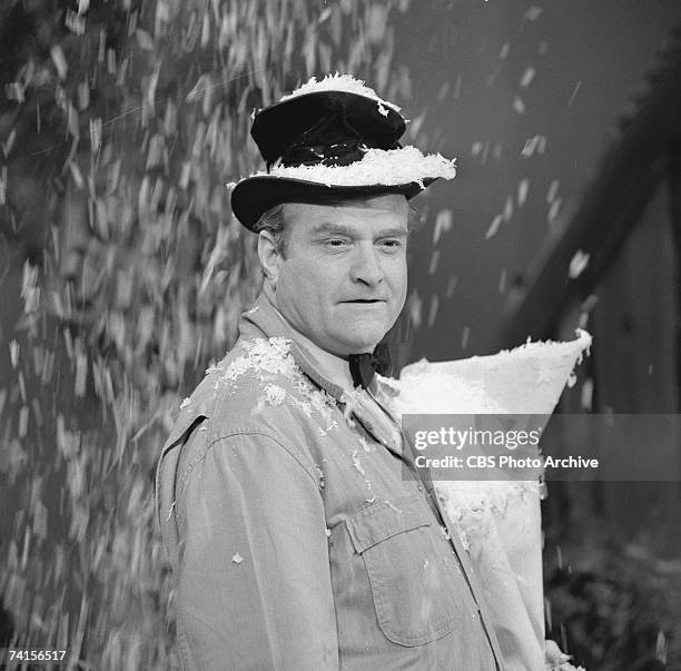 American actor and comedian Red Skelton stands in a blizzard of fake snow in a skit from the televison variety series, 'The Red Skelton Show,' March...