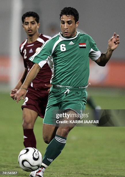 Abu Dhabi, UNITED ARAB EMIRATES: Iraqi football team player Saleh Sadir vies with Mesaad al-Hamad of Qatar during the 18th Gulf Cup championship...