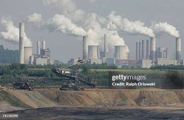 Behind the open-pit coal mine Gartzweiler exhaust rises from cooling towers at the lignit coal-fired power stations Frimmersdorf, Neurath and...