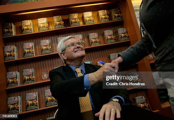 Former Speaker of the House Newt Gingrich shakes hands before signing his book "Pearl Harbor: A Novel of December 8th" at a Barnes and Noble...