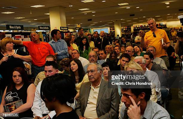 Crowd of people sit watching Former Speaker of the House Newt Gingrich as he signs copies of his book "Pearl Harbor: A Novel of December 8th" at a...