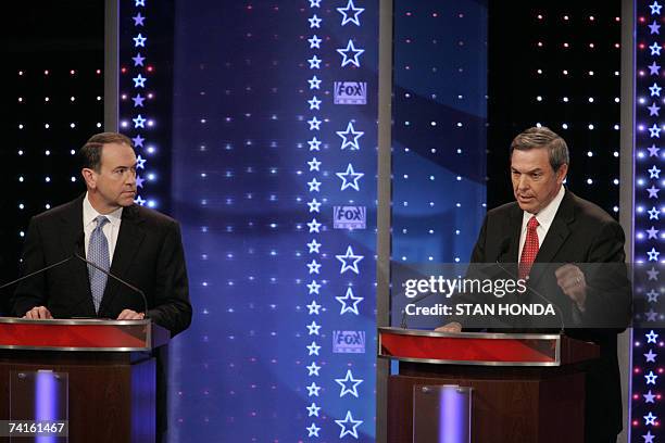 Columbia, UNITED STATES: Former Arkansas governor and Republican presidential hopeful Mike Huckabee listens as California Representative and fellow...