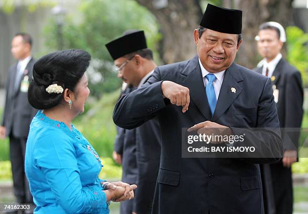 Jakarta, Java, INDONESIA: Indonesian President Susilo Bambang Yudhoyono shares a light moment with First Lady Kristiani as they wait to greet the...