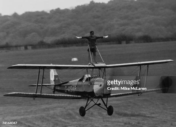 Stewardess Moira Boyd rides the wing of a Tiger Moth at Wycombe Air Park, Buckinghamshire, in preparation for an upcoming flying display at Denham,...