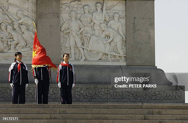 Member of the Chinese Communist Youth league gets wrapped up in his flag as he and his collegues stand at the Monument to the People's Heroes on...