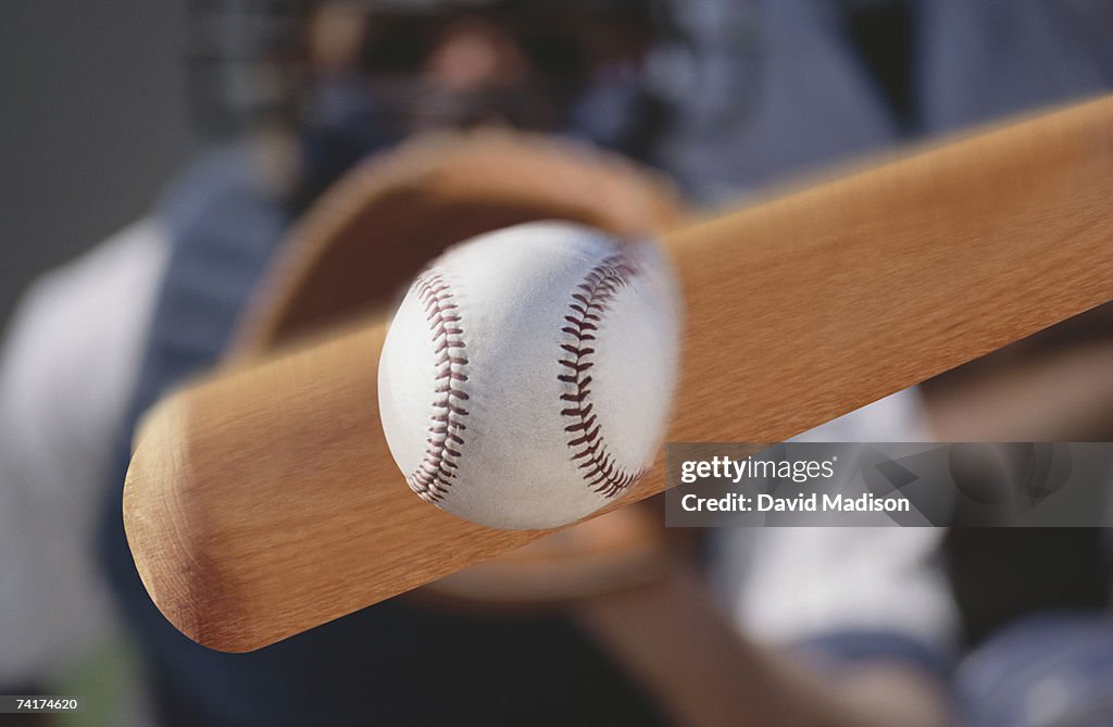 "Baseball bat hitting baseball, close-up "