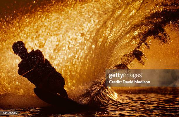 man waterskiing at sunset. - waterskiing stock pictures, royalty-free photos & images