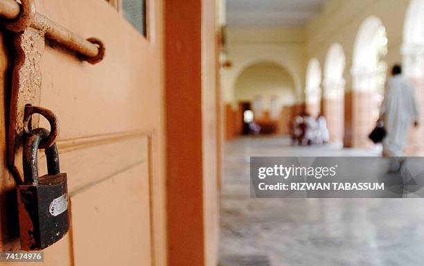 Pakistani man walks past a locked City court room during the lawyers' strike in Karachi, 17 May 2007. Pakistani lawyers countrywide boycotted the...