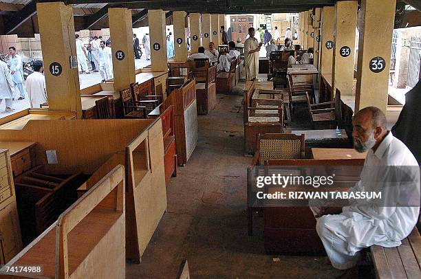Pakistani men sit in the city courts area during the lawyers' strike in Karachi, 17 May 2007. Pakistani lawyers countrywide boycotted the courts in a...