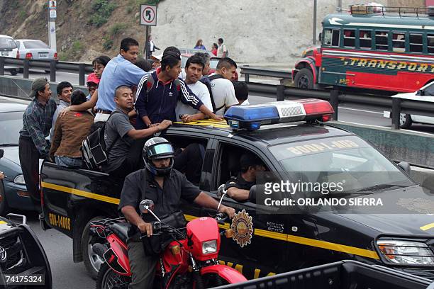 Guatemaltecos viajan en una patrulla de la Policia Nacional Civil durante el segundo dia de paro del transporte urbano, al norte de Ciudad de...
