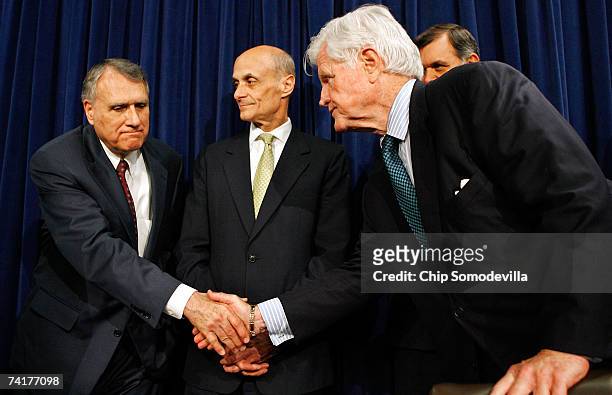 Sen. Jon Kyl shakes hands with Sen. Ted Kennedy as Homeland Security Secretary Michael Chertoff looks on during a news conference to announce a...