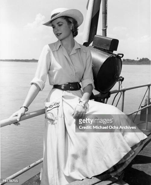 Actress Grace Kelly sits on the rail of a boat on the Magdalena river during filming of the MGM movie 'Green Fire' in 1954 in Columbia.