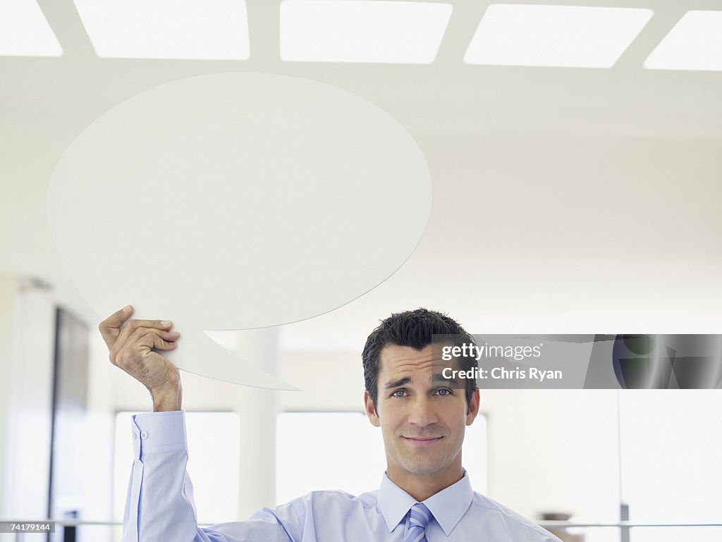 Businessman holding word balloon