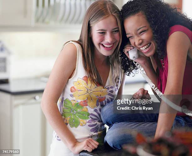 due ragazze adolescenti parlando al telefono ridere - landline phone home foto e immagini stock