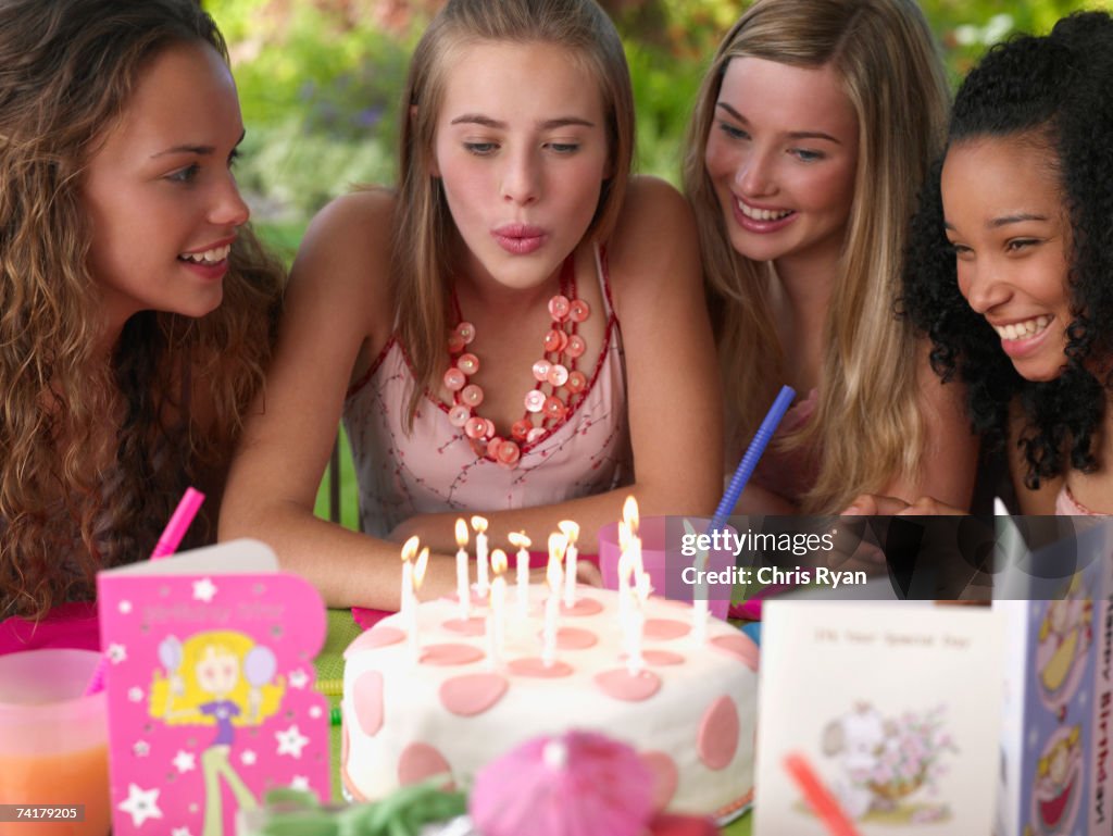Quatre jeunes filles à la fête d'anniversaire souriant à l'extérieur