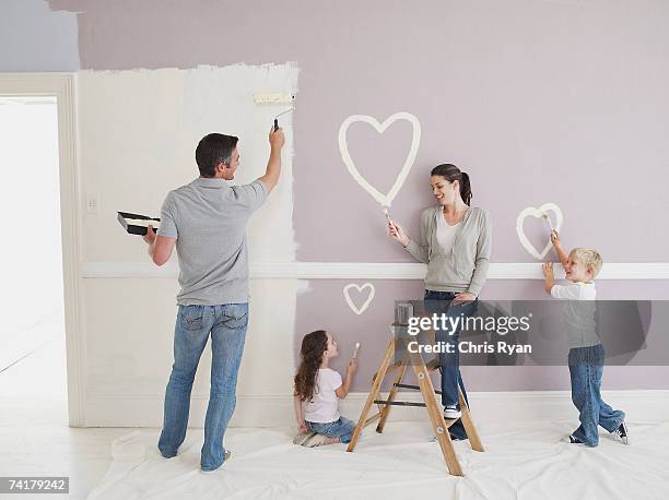hombre y mujer con niño y niña pintura corazones en pared - escalera plegable fotografías e imágenes de stock