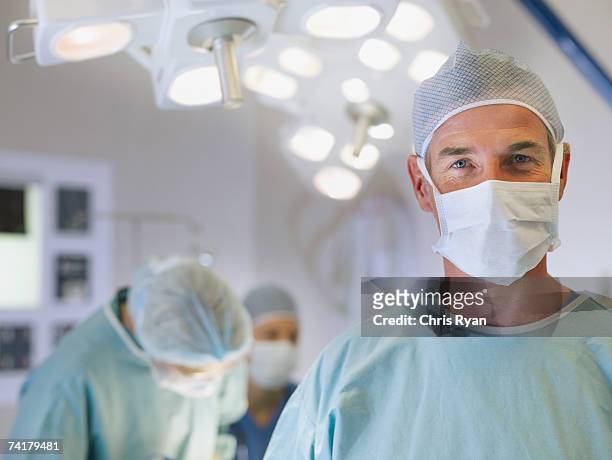 uomo in un camice da medico in sala operatoria - operating room foto e immagini stock