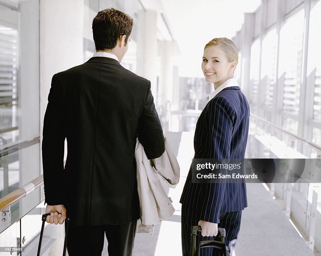 Businesswoman and man with luggage