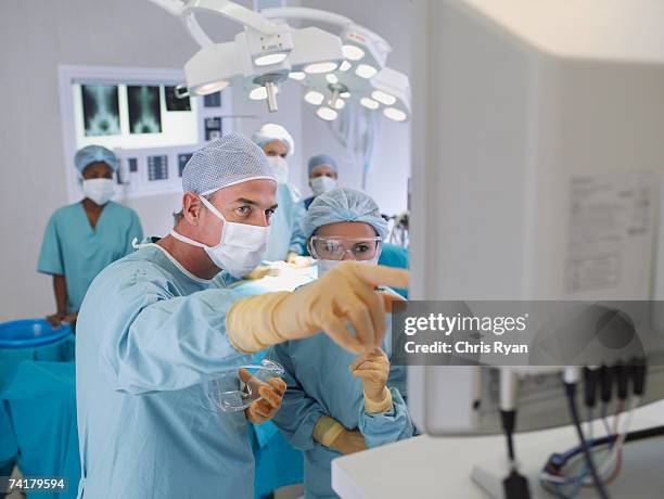 surgeon instructing in operating room - health guidance stock pictures, royalty-free photos & images