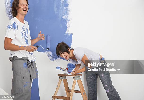 man and woman playing with paint - house painting stock pictures, royalty-free photos & images