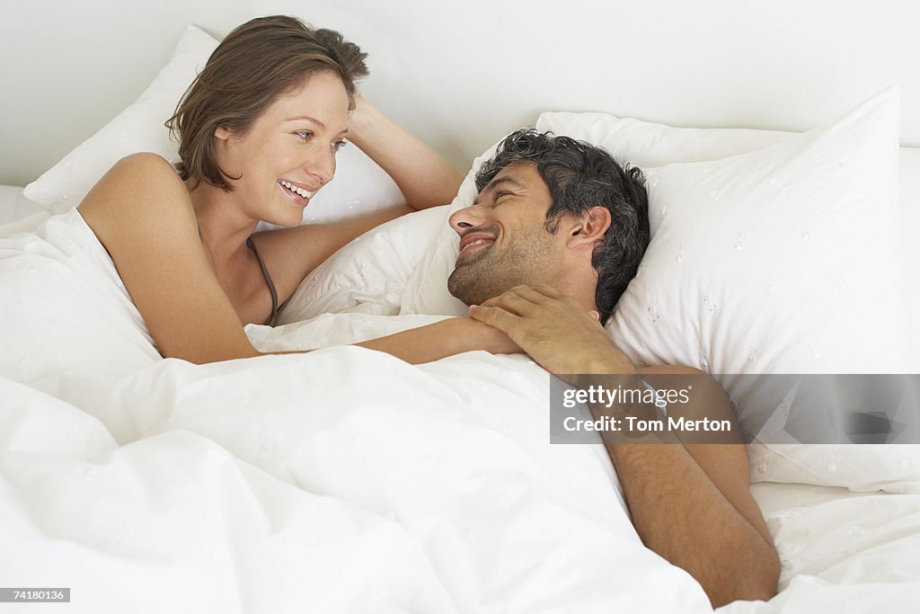 Woman and man lying down in bed