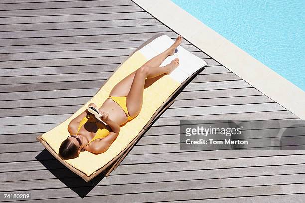 woman sunbathing on deck outdoors with book - swimming pool top view stock pictures, royalty-free photos & images