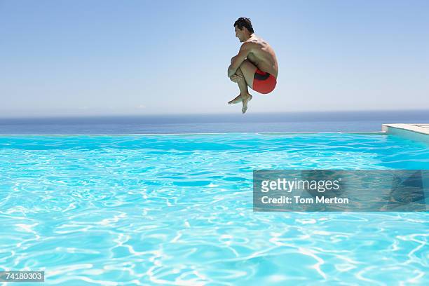 uomo i salti in piscina a sfioro - saltare foto e immagini stock