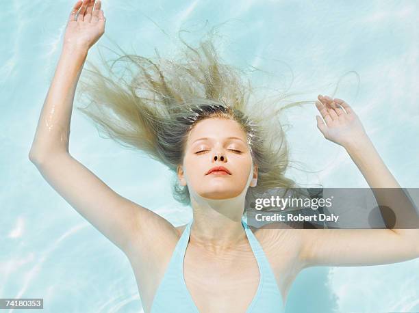 woman floating in water - wet hair stock pictures, royalty-free photos & images