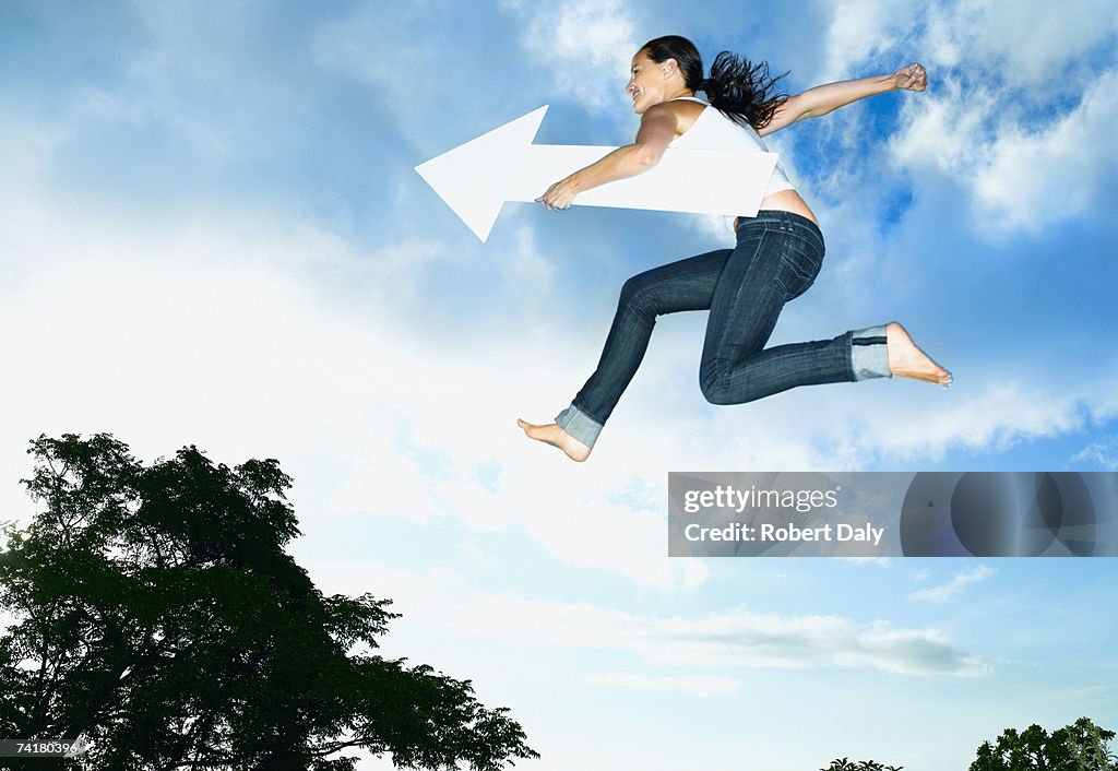 Mujer con flecha del salto del aire libre blanco