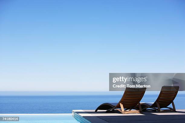 folding chairs on infinity pool deck - infinity pool stock pictures, royalty-free photos & images