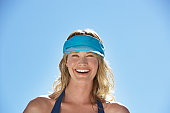 Woman in visor outdoors smiling