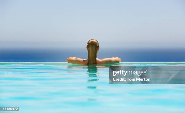 woman in infinity pool - woman pool relax stockfoto's en -beelden