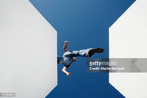 low angle view of man walking across high gap outdoors - men balancing stockfoto's en -beelden