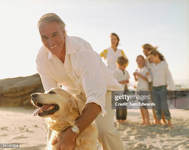 multigenerational family at beach with dog - multi generational family with pet stock pictures, royalty-free photos & images