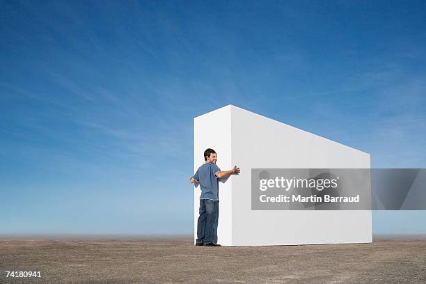 man hugging wall outdoors - a man goes through the wall stock pictures, royalty-free photos & images