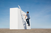 Man climbing ladder against wall outdoors