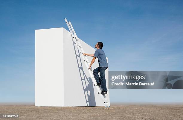 homem escalada escada contra a parede exterior - ladder imagens e fotografias de stock