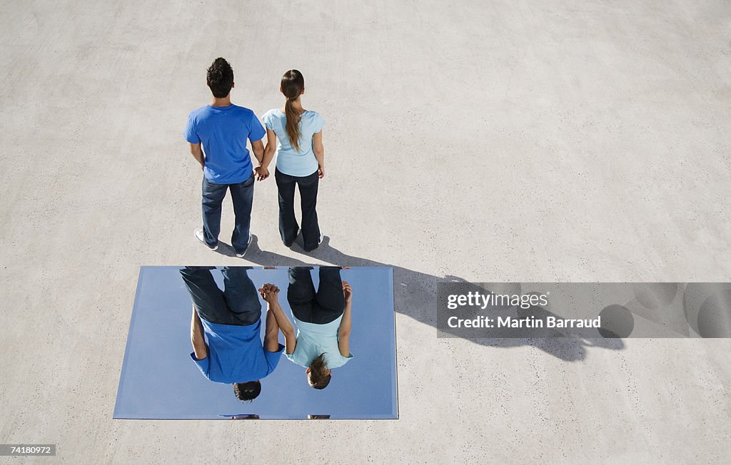 Vue arrière de l'homme et femme tenant les mains avec miroir