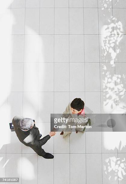 aerial view of businessman and businesswoman shaking hands - business relationship stock pictures, royalty-free photos & images